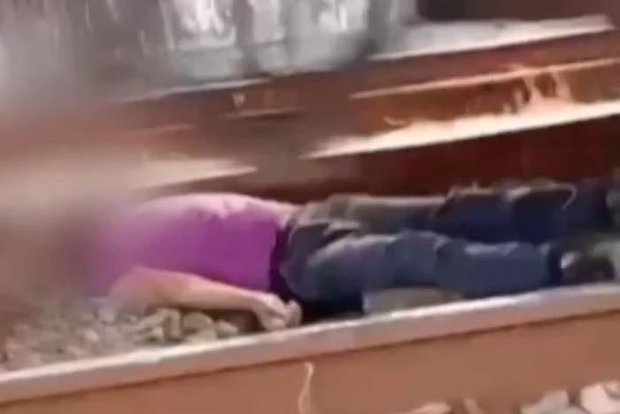Homem deita em trilho e espera trem passar sobre ele