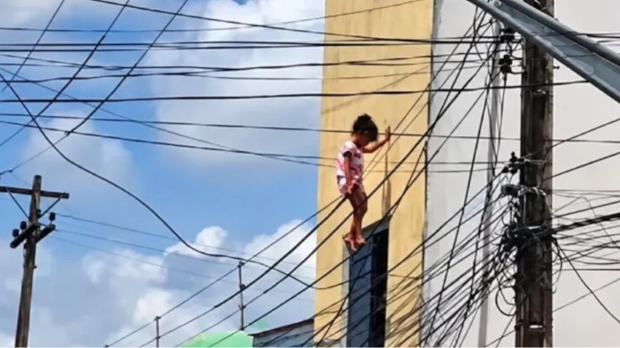 VÍDEO: Criança fica presa à fiação elétrica após cair do 2° andar de imóvel