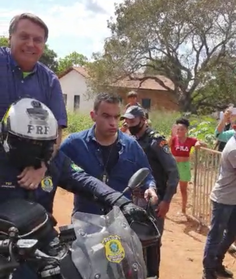 Bolsonaro pega carona em moto e anda no meio do povo em estrada carroçável; veja